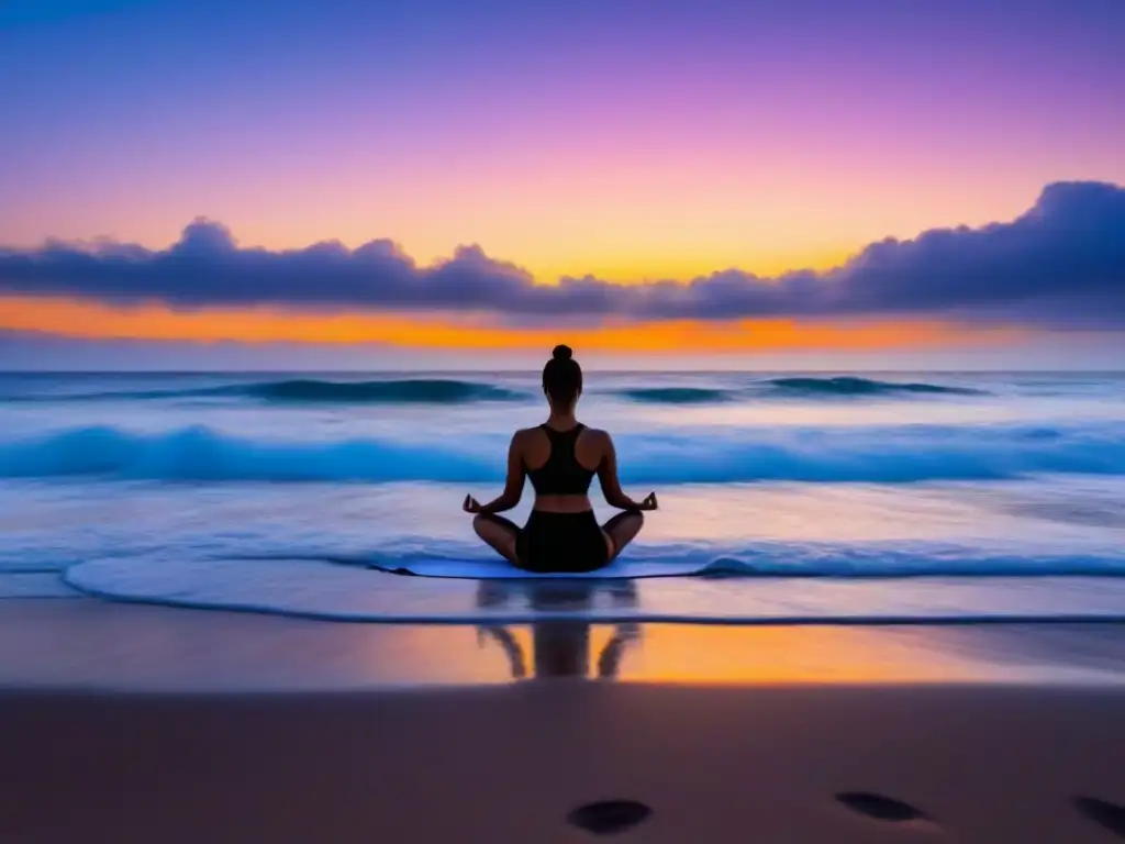 Meditación matutina en la playa: silueta practicando yoga al amanecer con olas suaves y cielo colorido