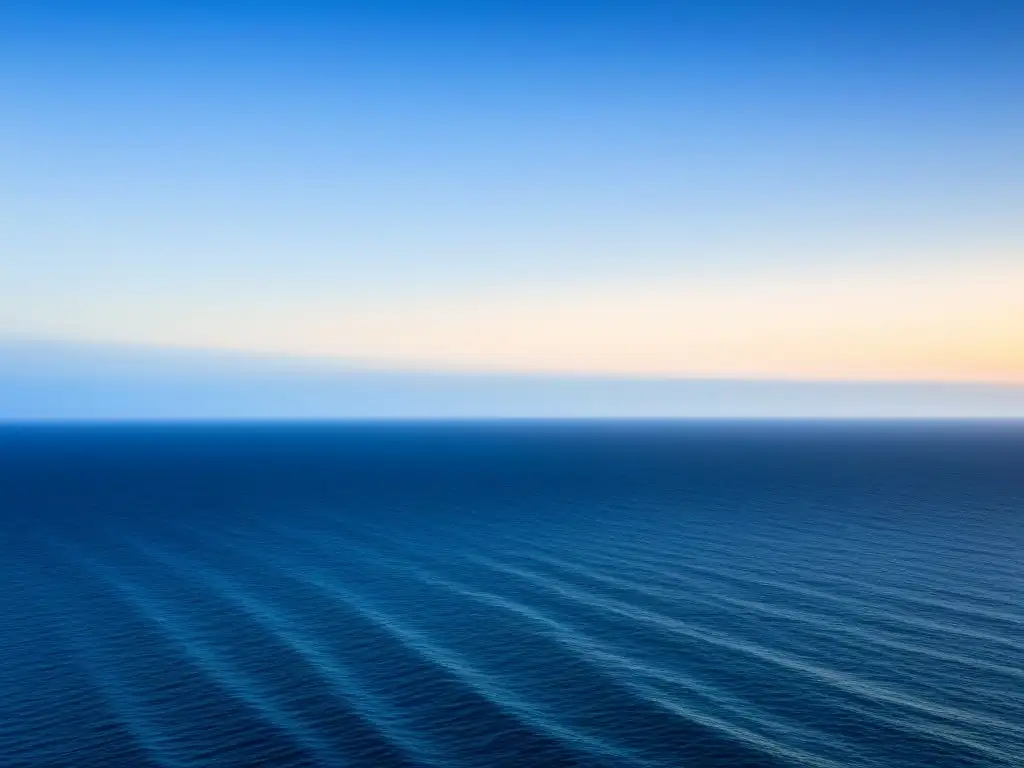 Un vasto océano azul profundo se extiende hasta el horizonte bajo un cielo despejado, creando una sensación de tranquilidad y belleza natural